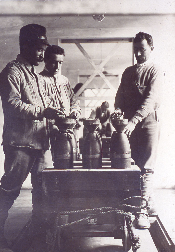 Il controllo delle industrie di materiale bellico: nell'immagine, operai intenti al caricamento degli shrapnels da 149, Bologna, Prati di Caprara (Museo civico del Risorgimento di Bologna).