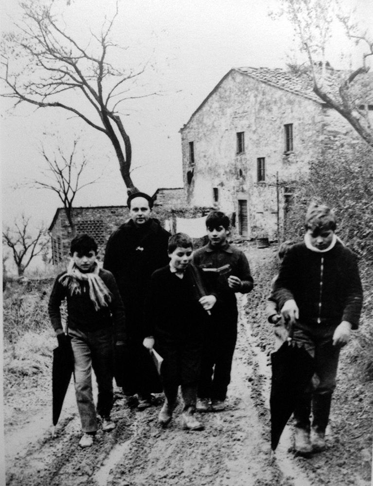 Lorenzo Milani a Barbiana, assieme ai suoi ragazzi (foto di Oliviero Toscani, Archivio Milani, Fscire).
