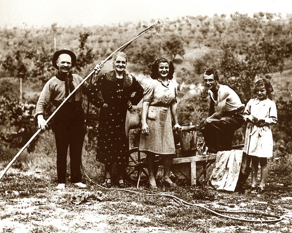 Famiglia in posa accanto alla pompa a mano per gli antiparassitari, anni Trenta-Quaranta [Archivio Gruppo Mezaluna - Mario Menabue, Fondo Fausto Simonini]